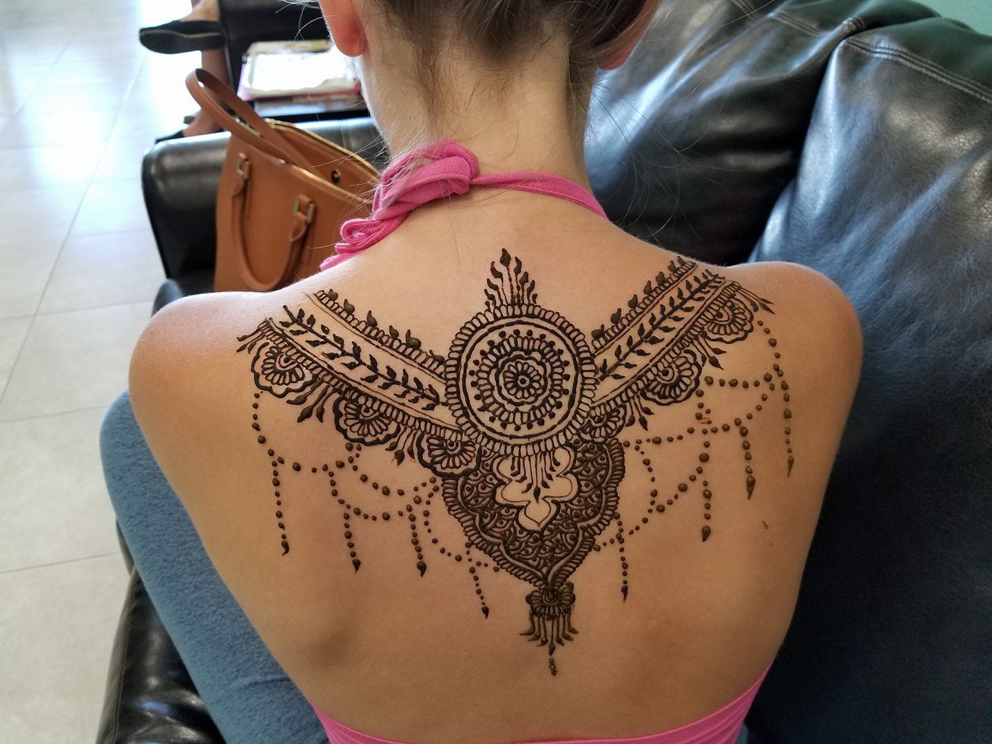 A woman with henna tattoos on her back.